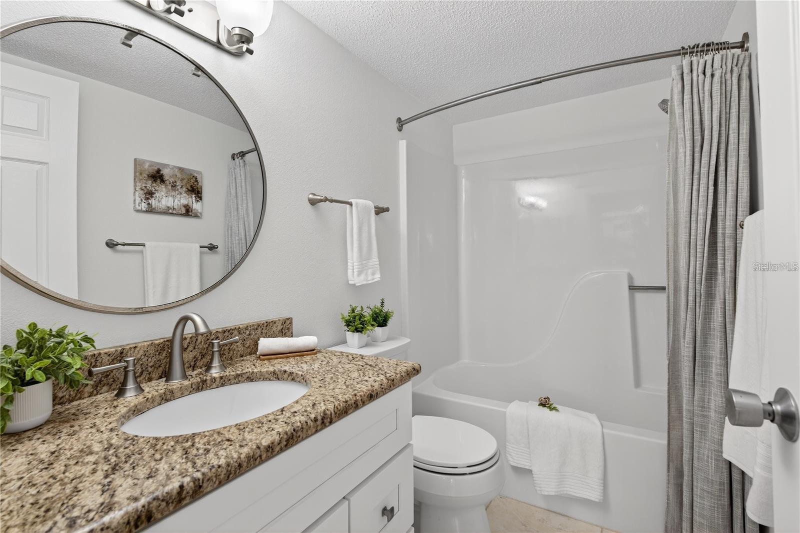 Second Bathroom with Granite-Topped Vanity and Tub and Shower Combination