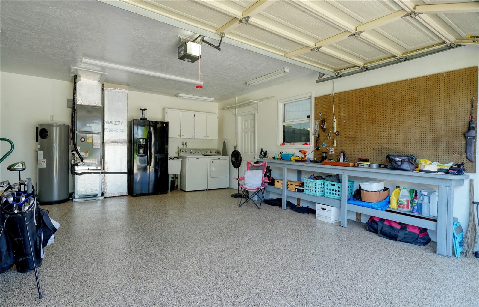 Epoxy coated floor in 2 car garage, with laundry and second refrigerator and workbench - side door leads to RV/Boat trailer parking pad behind double door Vinyl fence
