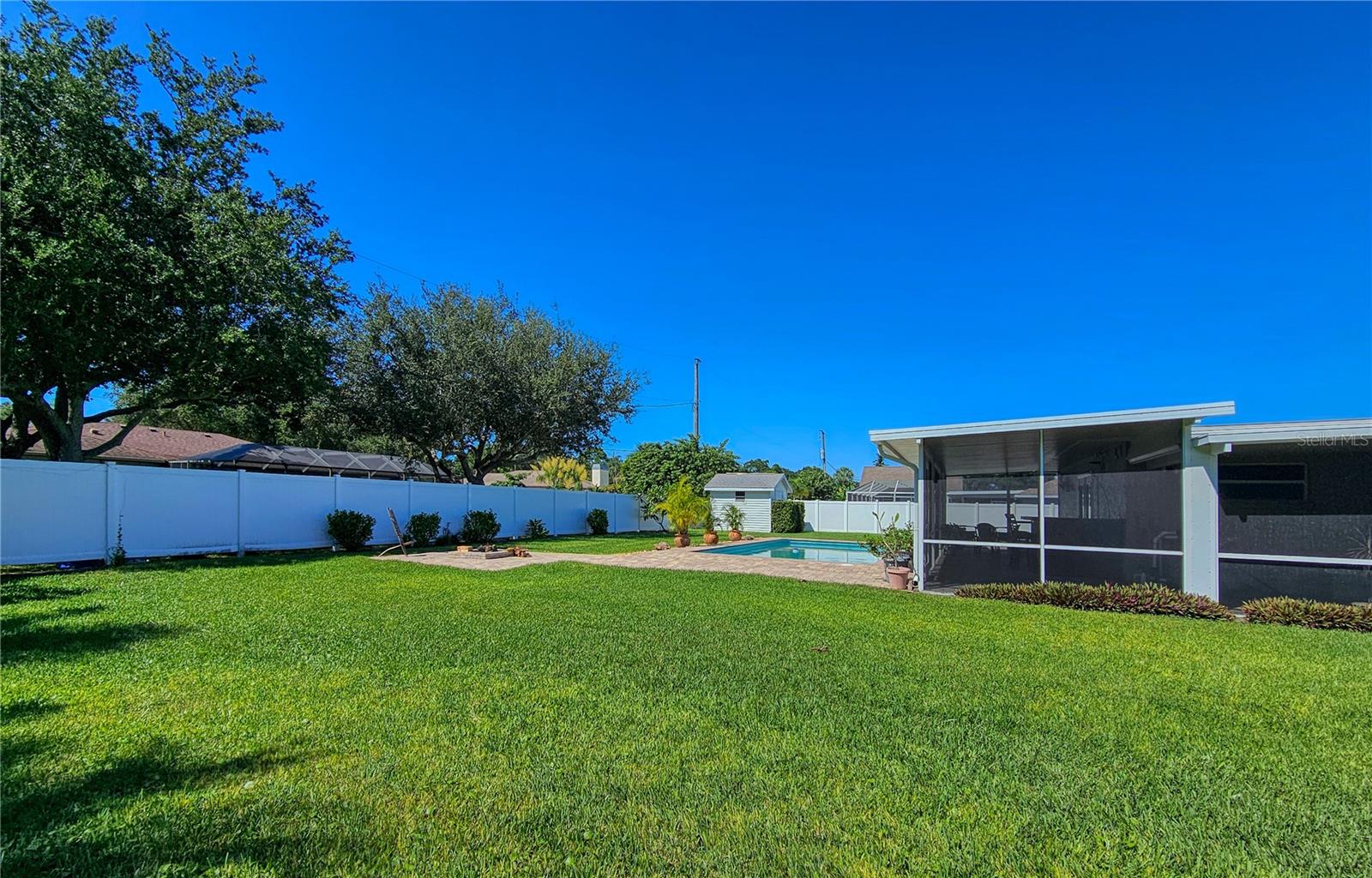 Large side yard behind 6' vinyl privacy fence, room to roam