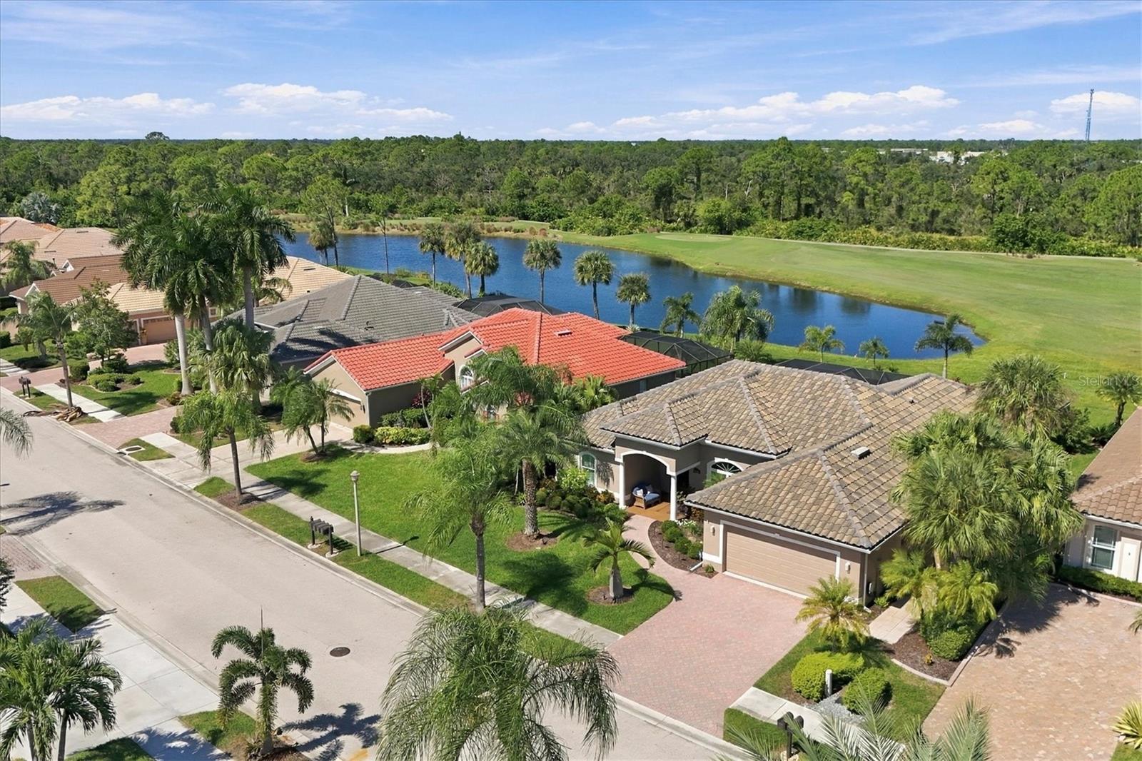 Note lovely covered entry and handsome pavered driveway and walkway. Lake and fairway views of #2 of the Creek Course. Tile roof new 3/2024