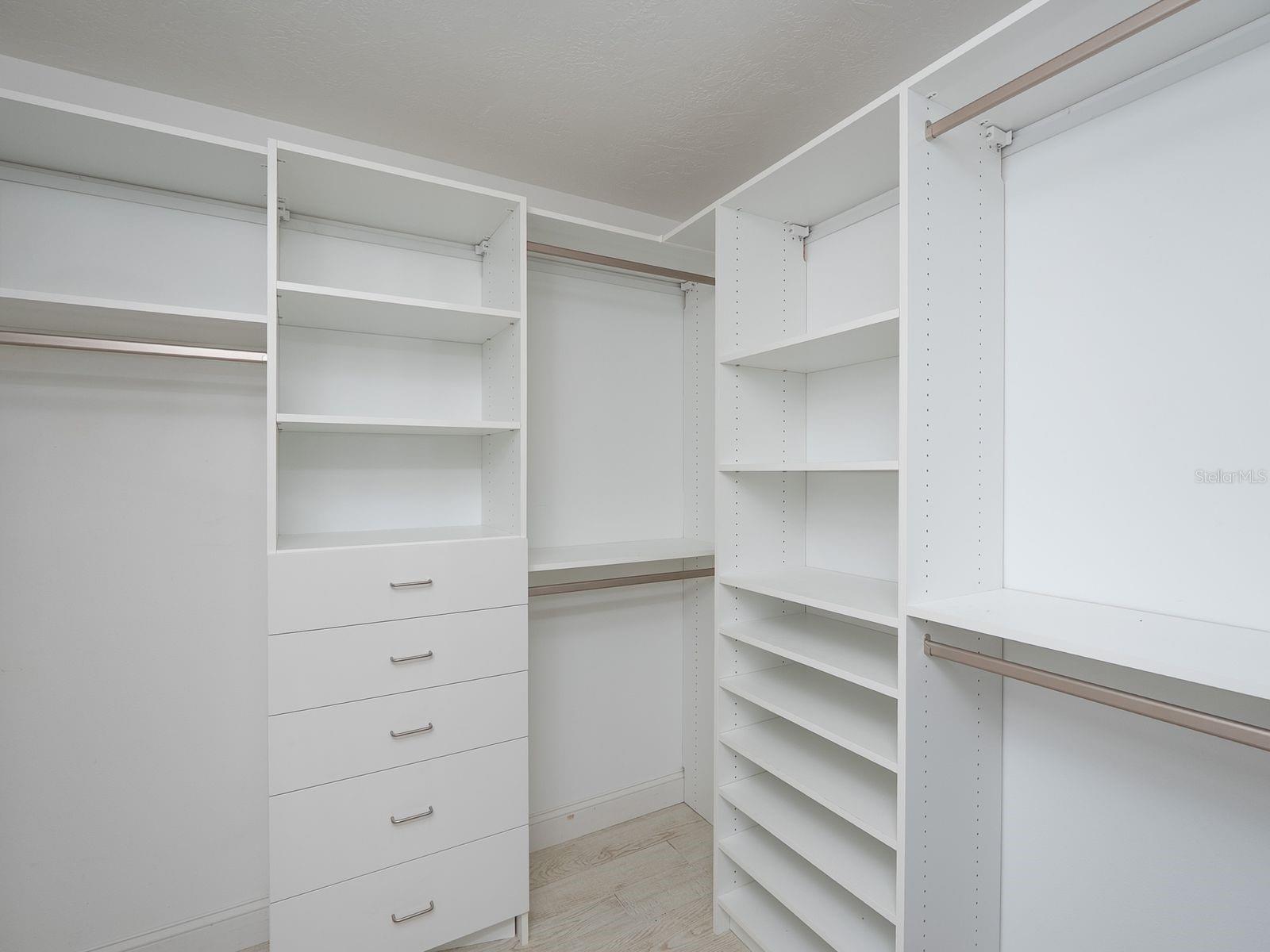 primary walk in closet with built in organizers