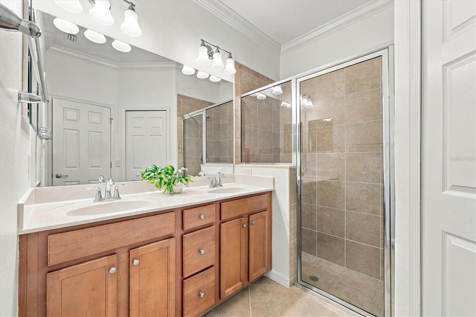 Dual Sinks & Glass Step-In Shower Stall in Primary Bath