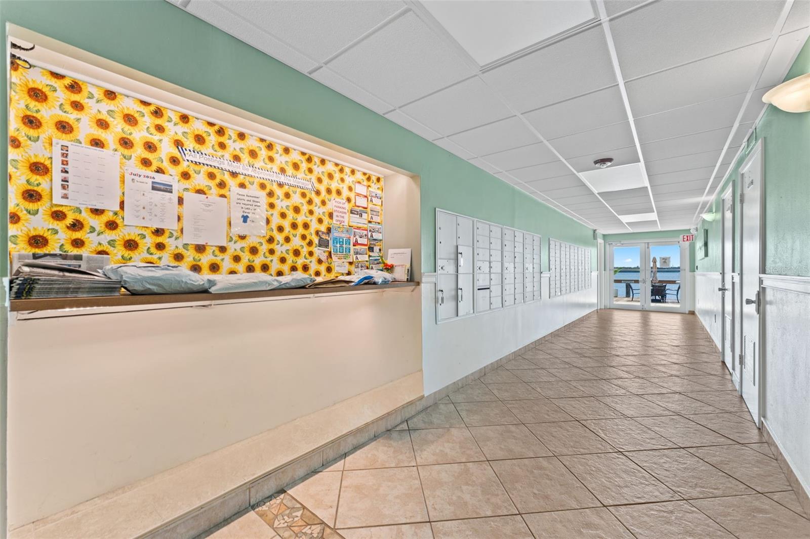 Community Information board, mailboxes, bathrooms, sauna & doors to BBQ & pool areas.