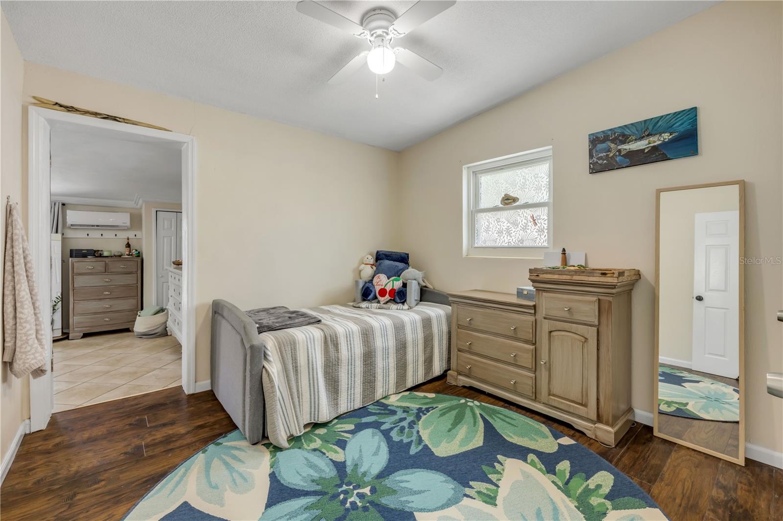 Bedroom with wood flooring and a ceiling fan.