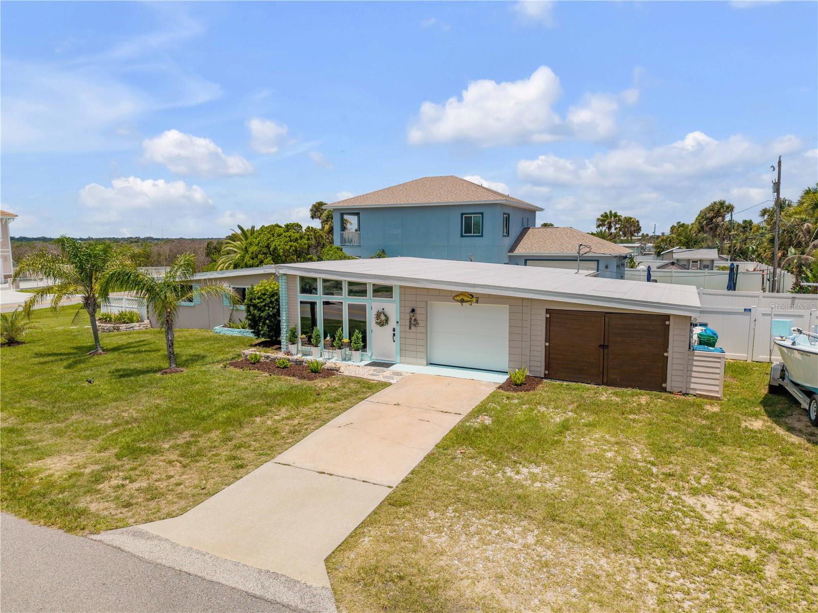 Front exterior with a broad lawn, driveway and attached garage.