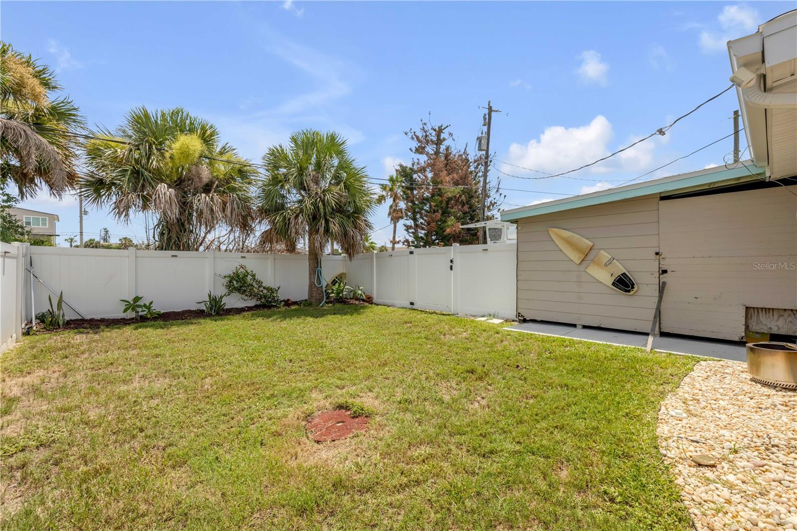 Fenced yard with lawn and detached outbuilding.