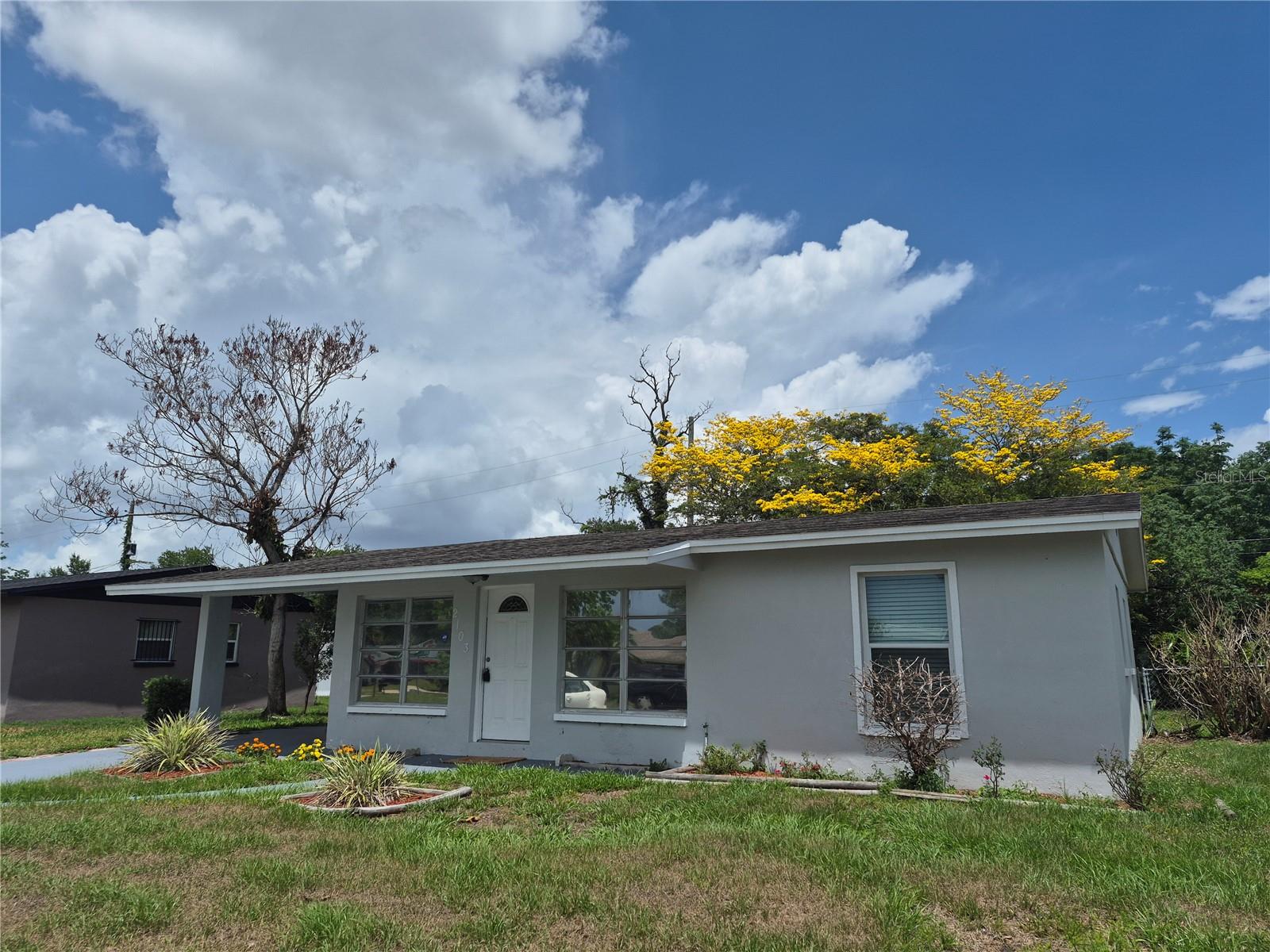 Home exterior featuring the backyard tree in bloom Home exterior featuring the backyard tree in bloom