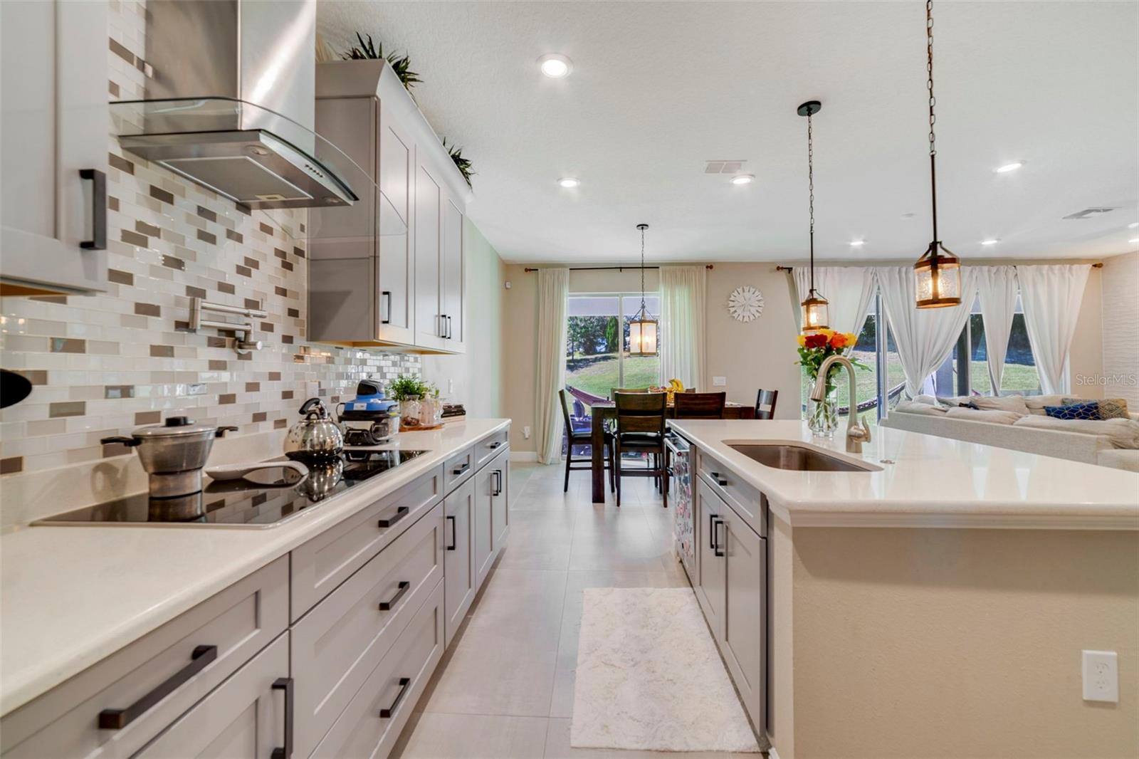 The DREAM KITCHEN is a showstopper with stylish cabinetry, stone countertops, a breakfast bar, built-in oven, cooktop stove with POT FILLER, tile backsplash, walk-in pantry, and a GALLEY-STYLE COFFEE BAR AREAperfect for morning routines or entertaining. The DREAM KITCHEN is a showstopper with stylish cabinetry, stone countertops, a breakfast bar, built-in oven, cooktop stove with POT FILLER, tile backsplash, walk-in pantry, and a GALLEY-STYLE COFFEE BAR AREAperfect for morning routines or entertaining.