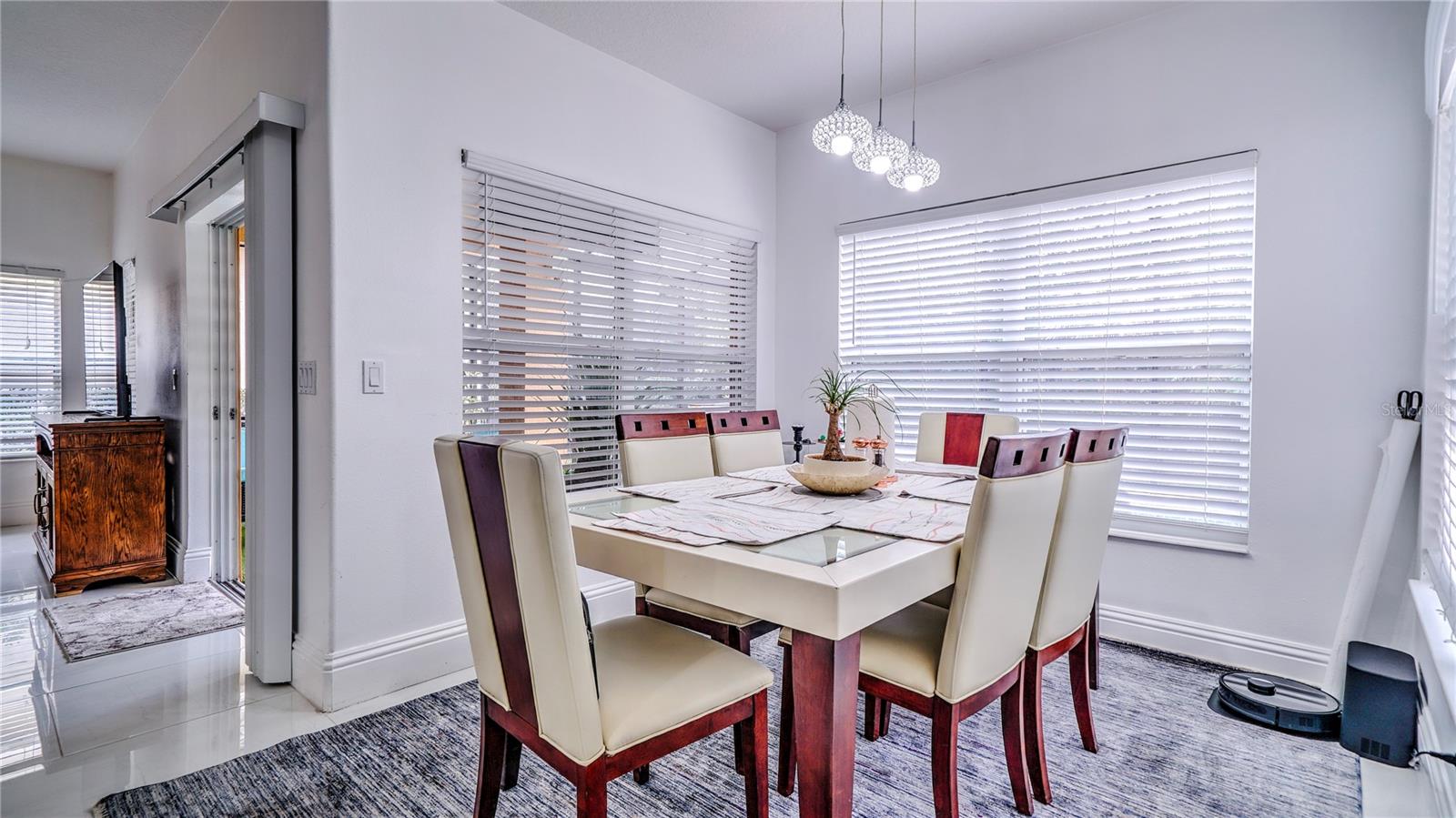 Dining room connected to the kitchen with a view of the pool area.