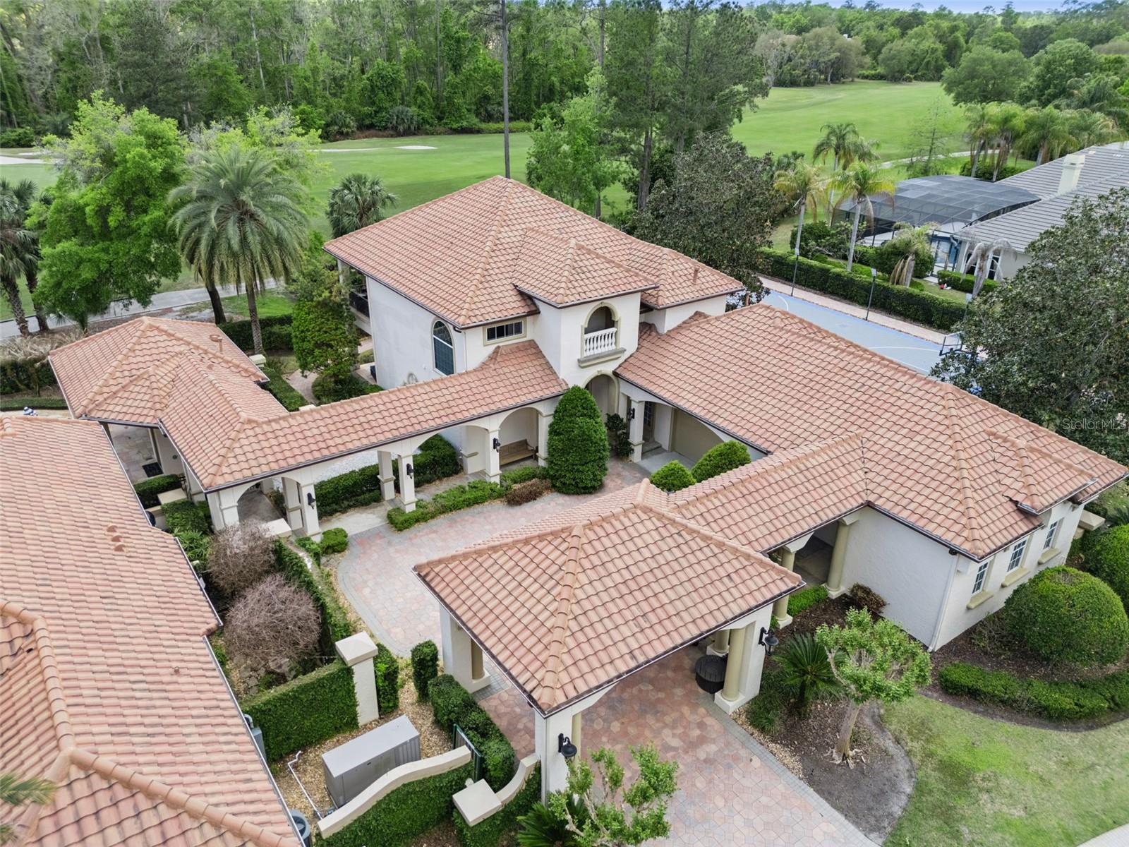 Separate Guest House with a 2 car garage and a golf cart bay with garage door on back side of the garage with a pavered path leading to the golf course.