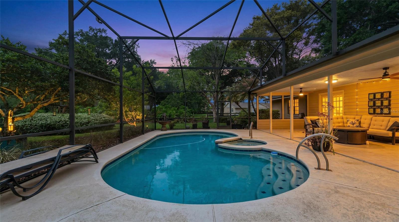 Breathtaking resort-style pool and spa within a screened enclosure, complemented by a covered outdoor living area--designed for elegant entertaining and serene evenings.