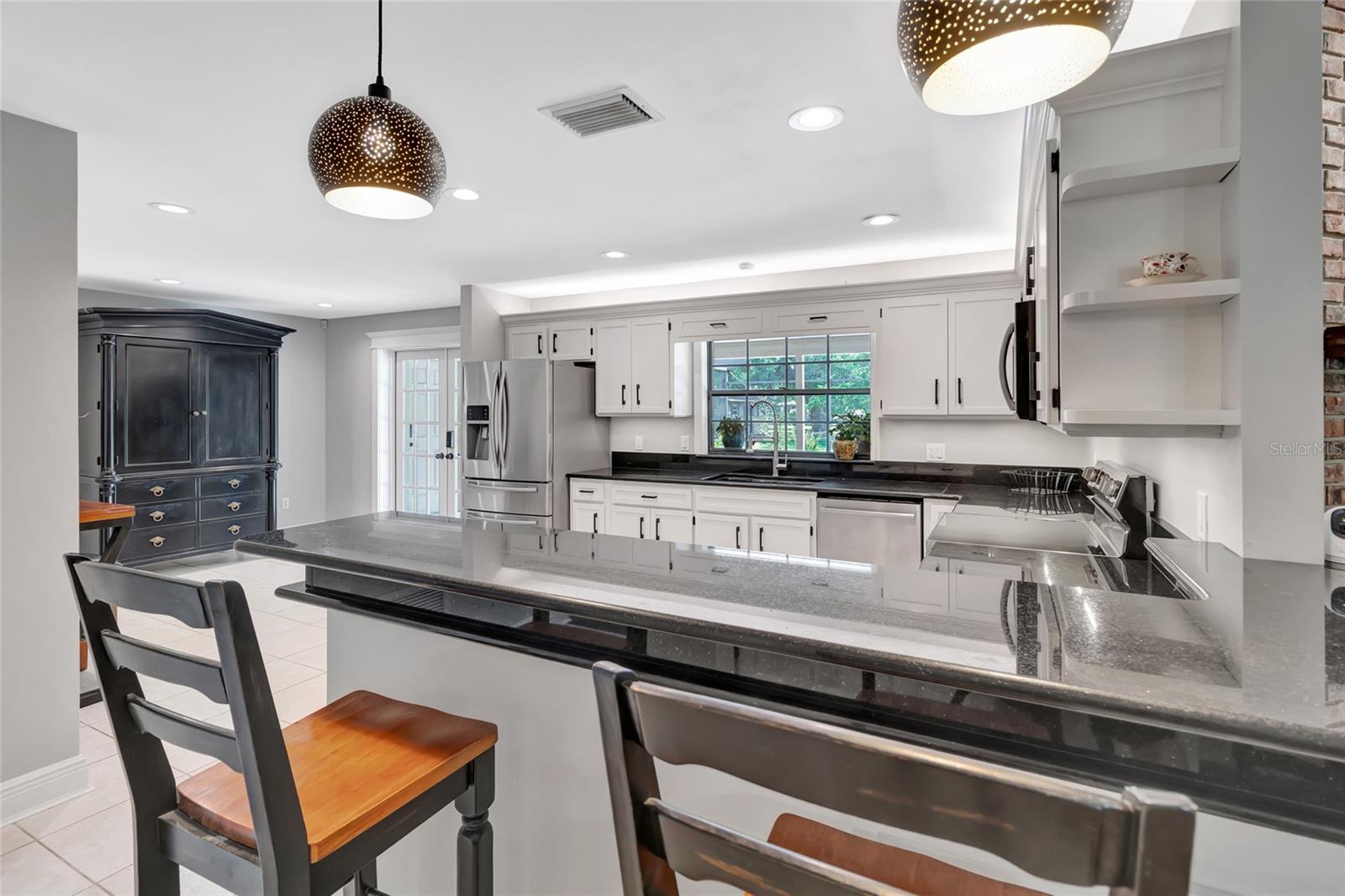 Stunning open kitchen showcasing an oversized breakfast bar, granite countertops, and a flexible layout with space for a breakfast table-designed for effortless entertaining.