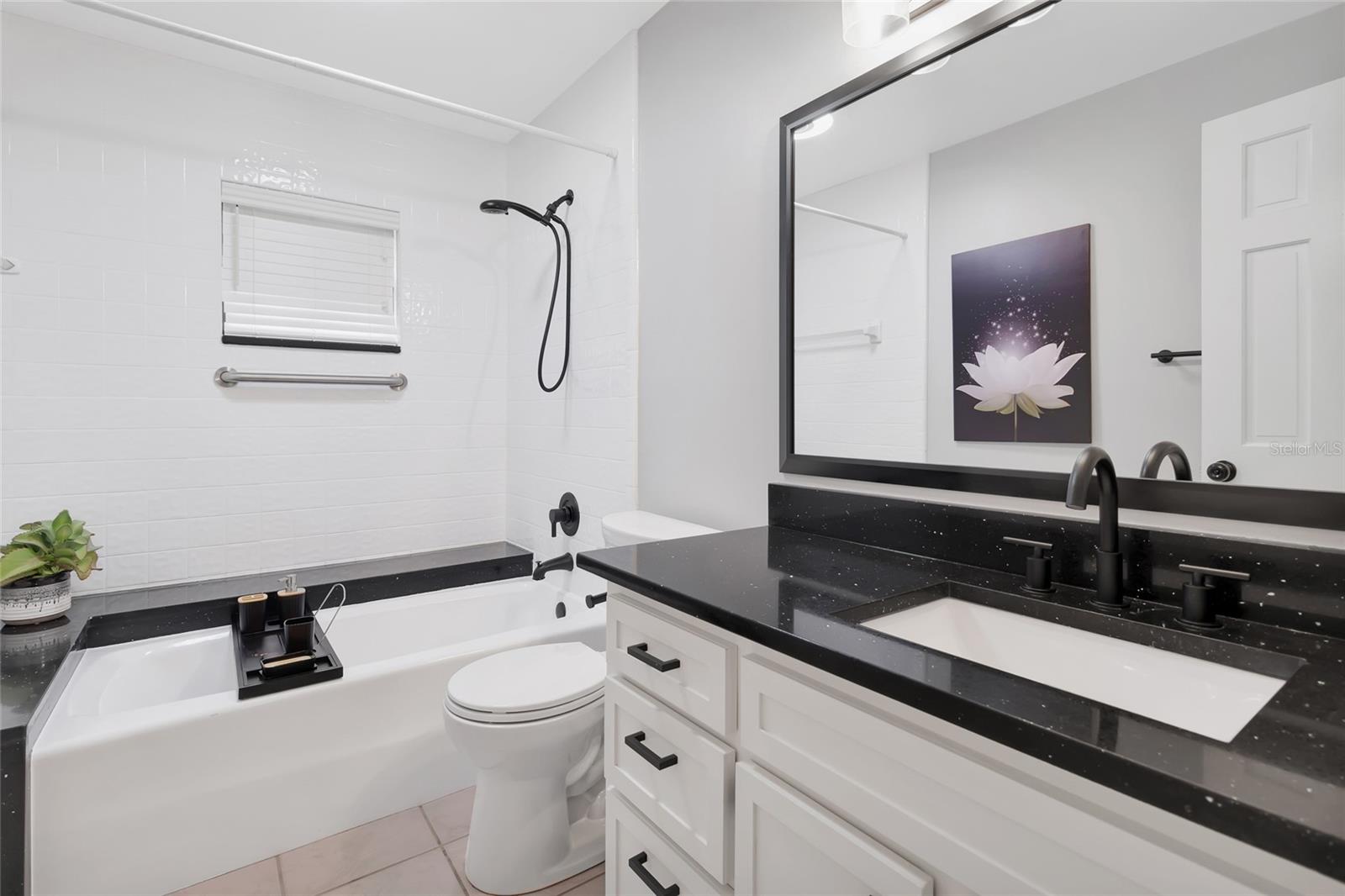Elegantly updated bath showcasing granite countertops, designer fixtures, and a refined, spa-like ambiance.