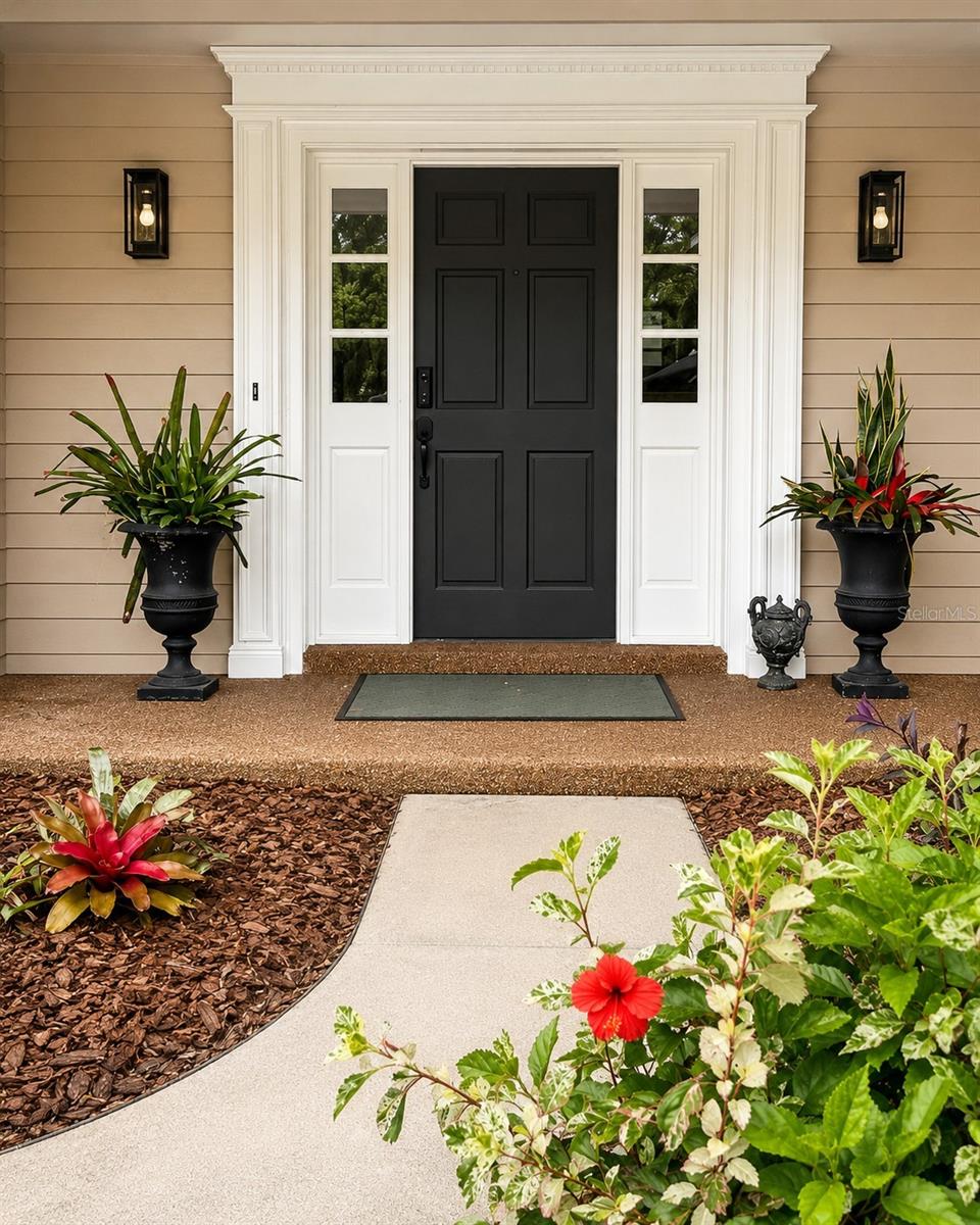 Grand, inviting entry highlighted by detailed millwork, designer lighting, and a striking front door- an elegant introduction to the home.