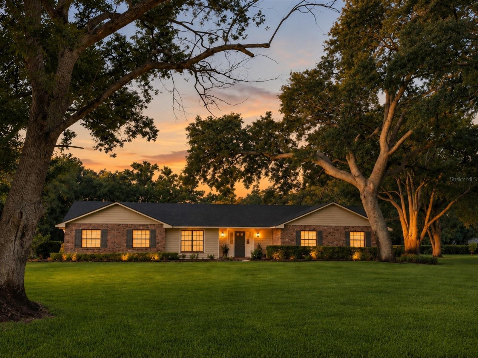 Twilight view of this beautiful pool home on over an acre of land with mature trees. Twilight view of this beautiful pool home on over an acre of land with mature trees.
