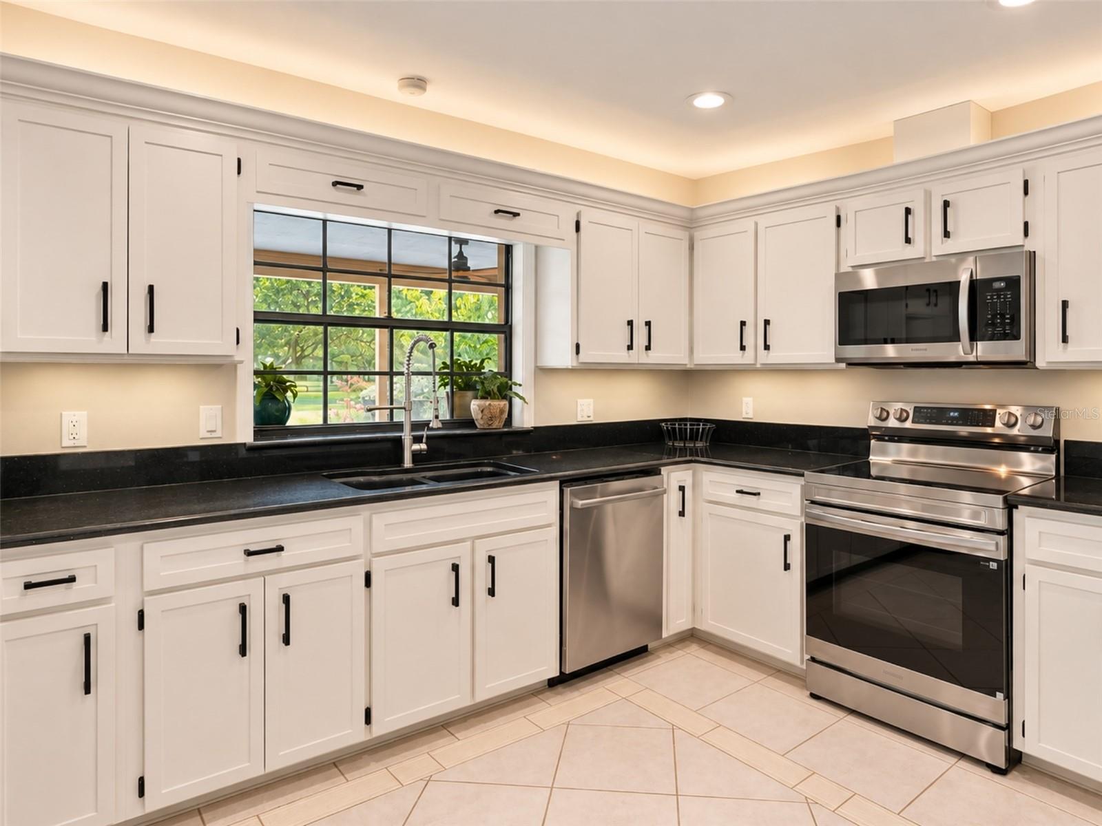 Bright kitchen with abundant cabinetry, granite countertops, stainless steel appliances, and a brand new rang with air fry feature- plus under-and above- cabinet lighting. Pass-through window to the pool with serving counter makes outdoor entertaining effortless.
