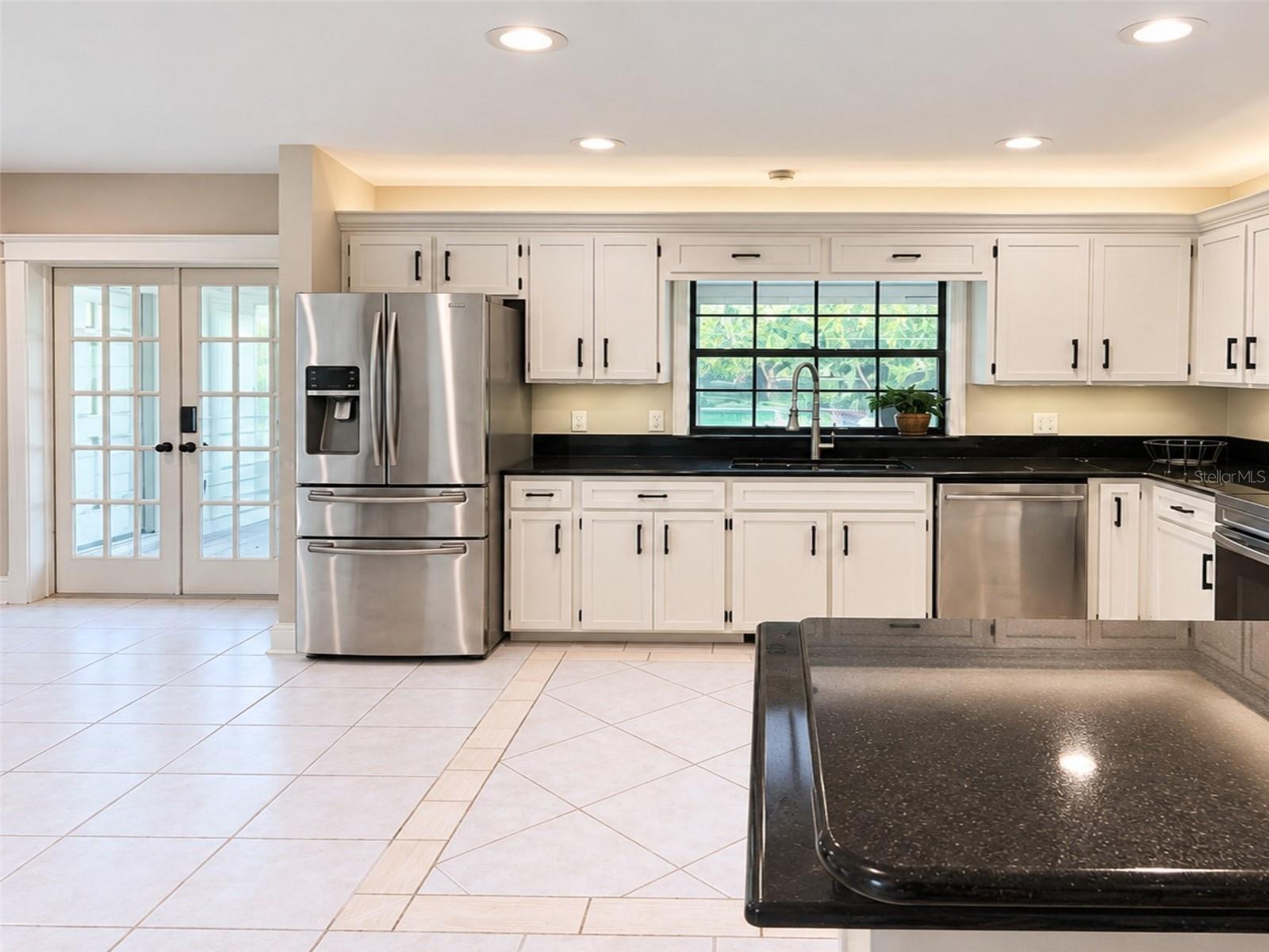 Bright kitchen with abundant cabinetry, granite countertops, stainless steel appliances, and a brand new rang with air fry feature- plus under-and above- cabinet lighting. Pass-through window to the pool with serving counter makes outdoor entertaining effortless.
