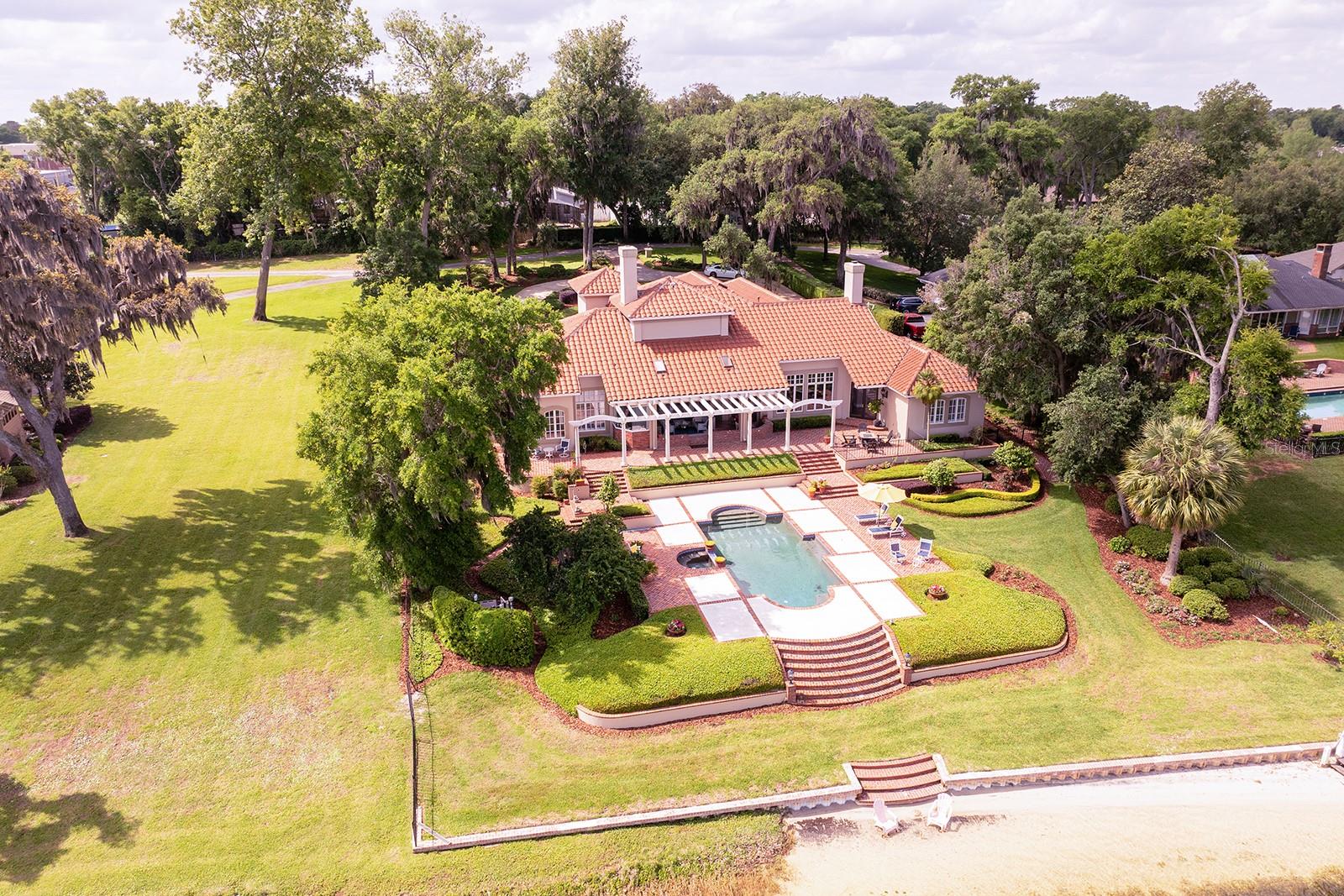 firm. Every detail reflects elegance and grace for the most discerning homeowner. The cultivated beauty of this one-owner home is nestled on a lush, private enclave, occupying an oversized four-acre lot with **1 + acre dedicated to the residence itself.
