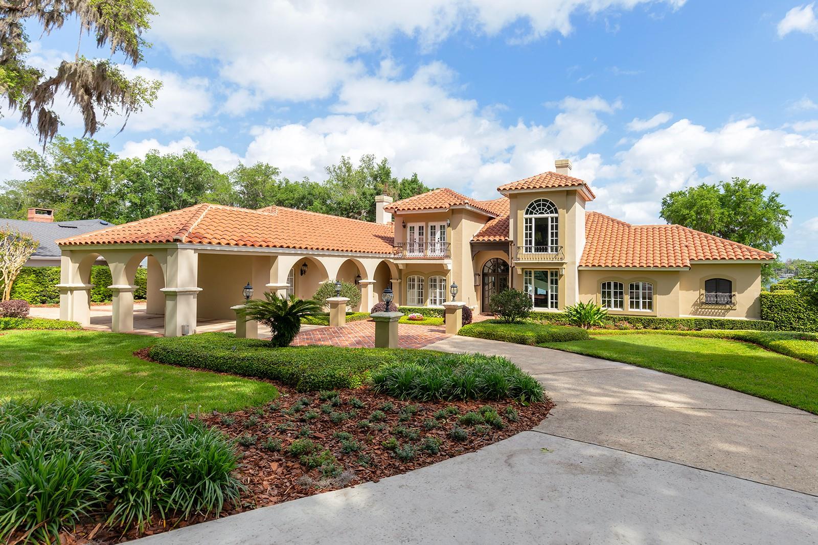 Biltmore GAS LANTERNS, SHUTTERS, BALCONIES & TOWERING tree canopies as you approach this MEDITERRANEAN-RIVIERA style estate.