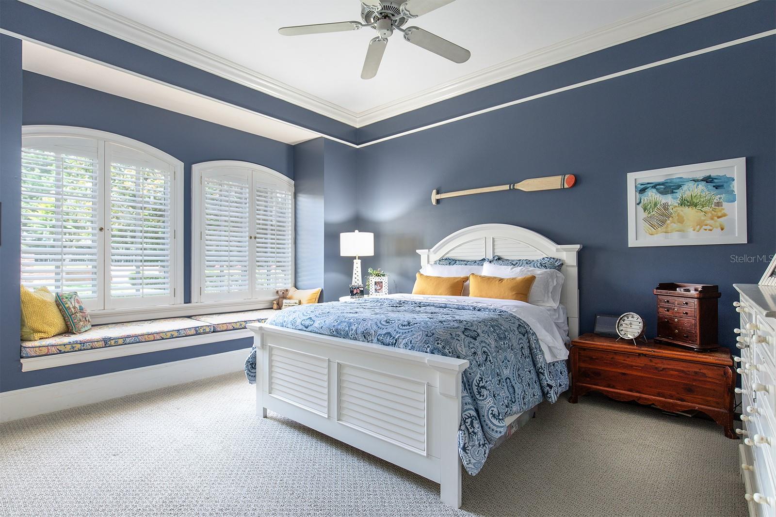 One of the many beautifully designed bedrooms, with lots of light, plantation shutters and even a window seat to enjoy the grounds.