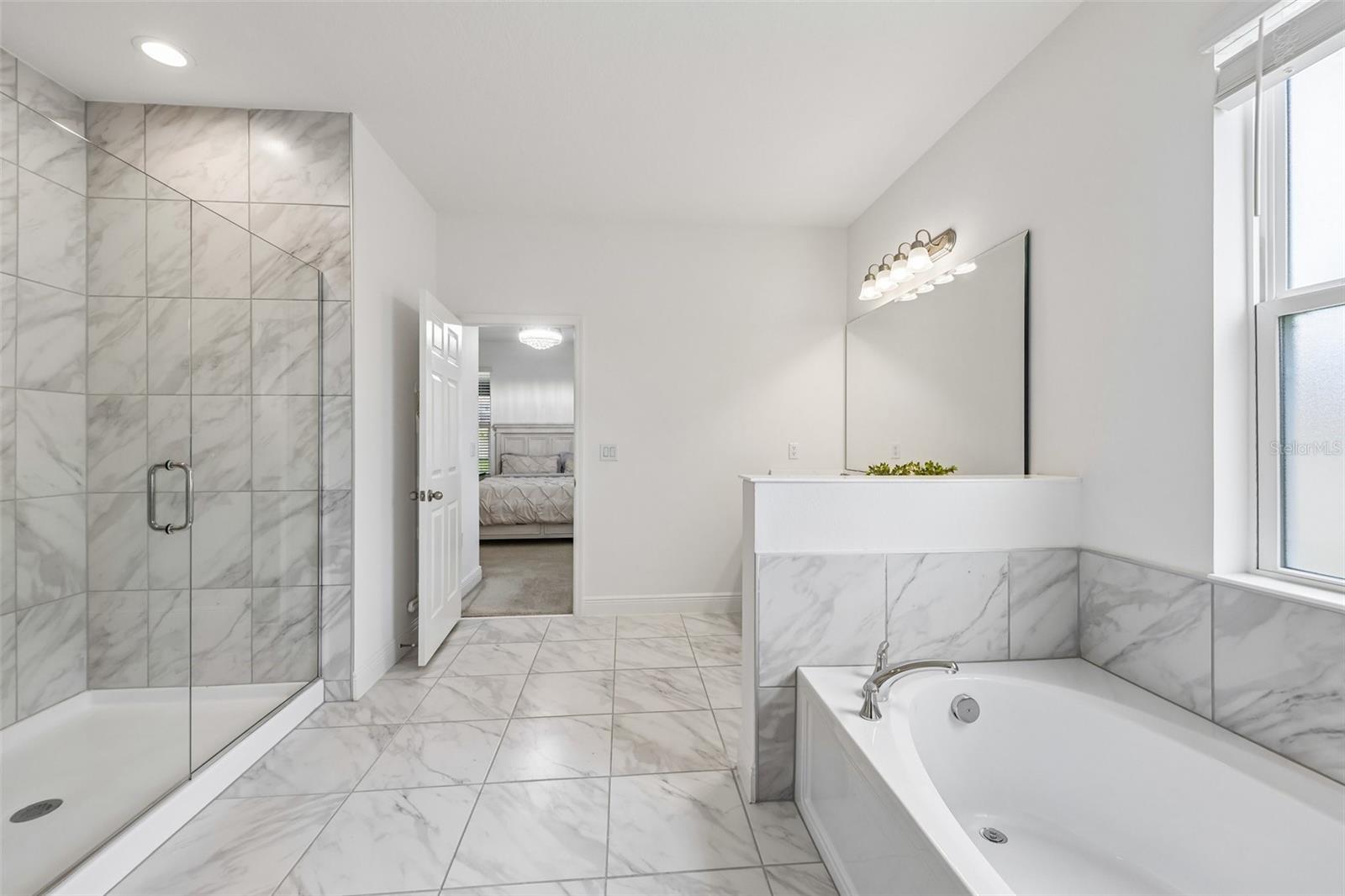 Upgraded en-suite bath includes a soaking tub and separate glass enclosed shower.