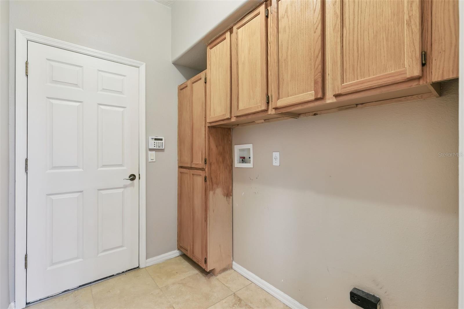 Designated laundry room with storage.