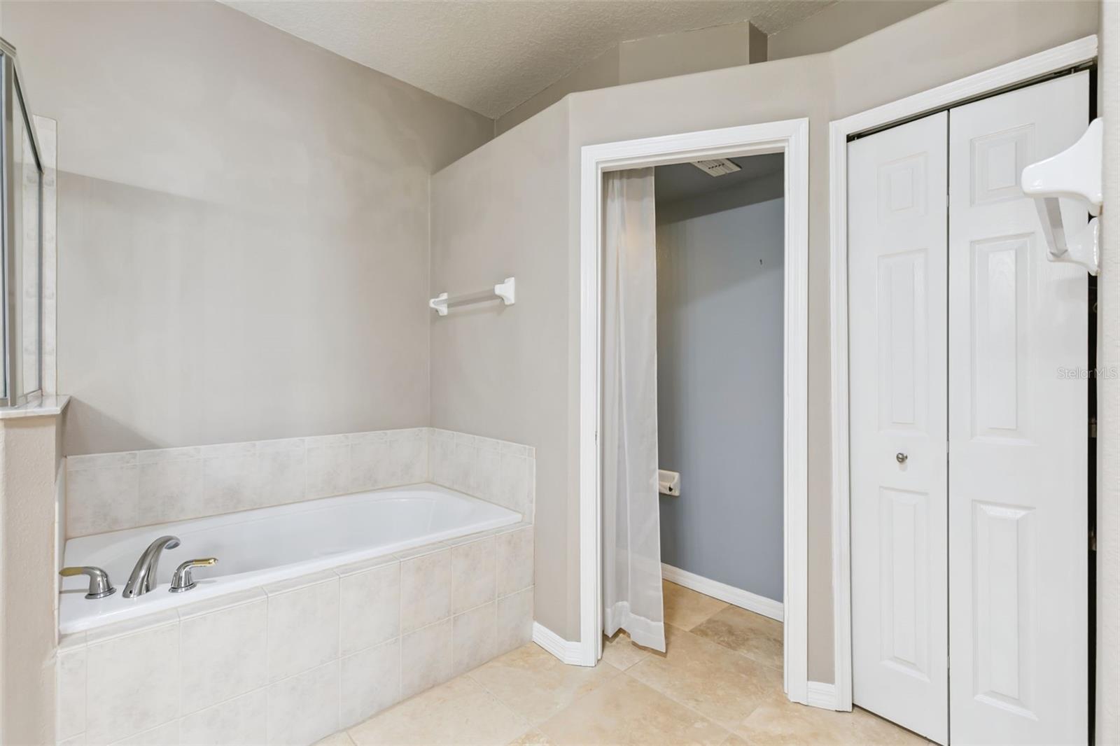 Garden tub and linen closet in primary bathroom.