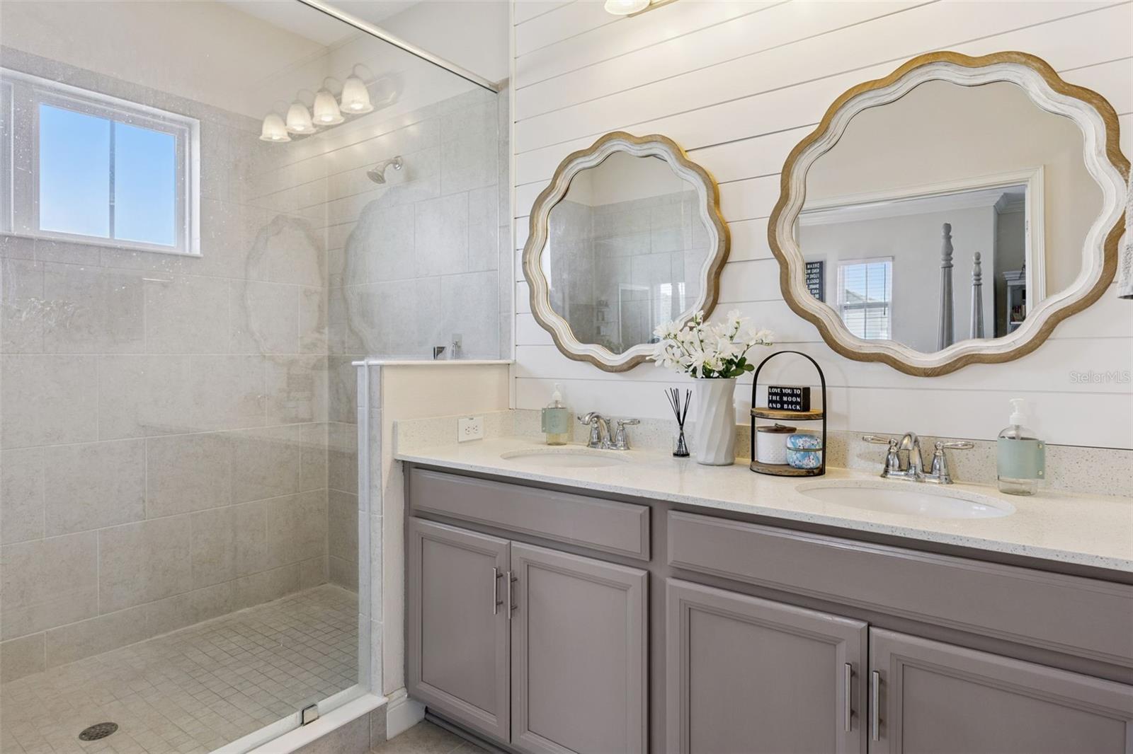 Primary bath features dual sinks, an oversized shower, linen closet, and private toilet.