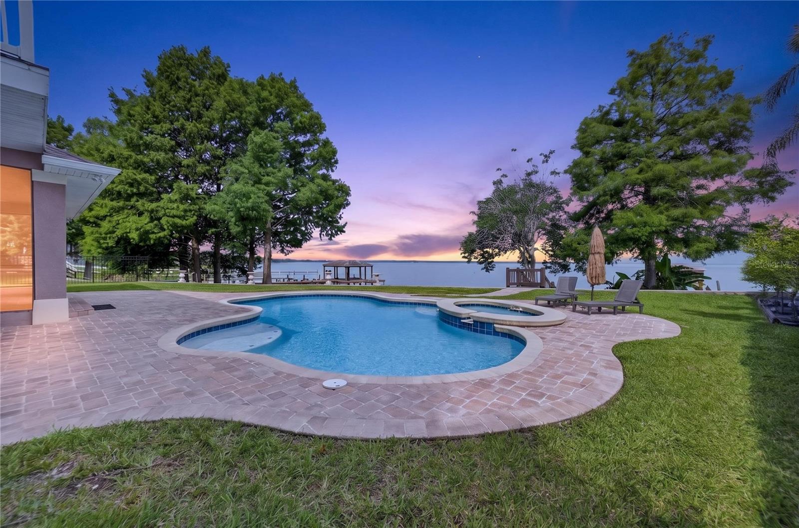 Amazing sunsets from the incredible outdoor living space with well designed heated pool and raised spa, lounging area and dock