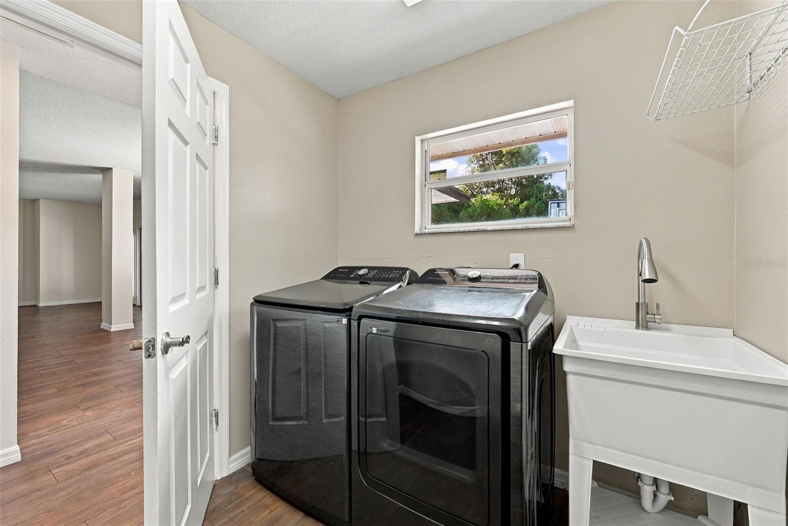 Downstairs laundry room with new utility sink and half pool bath access
