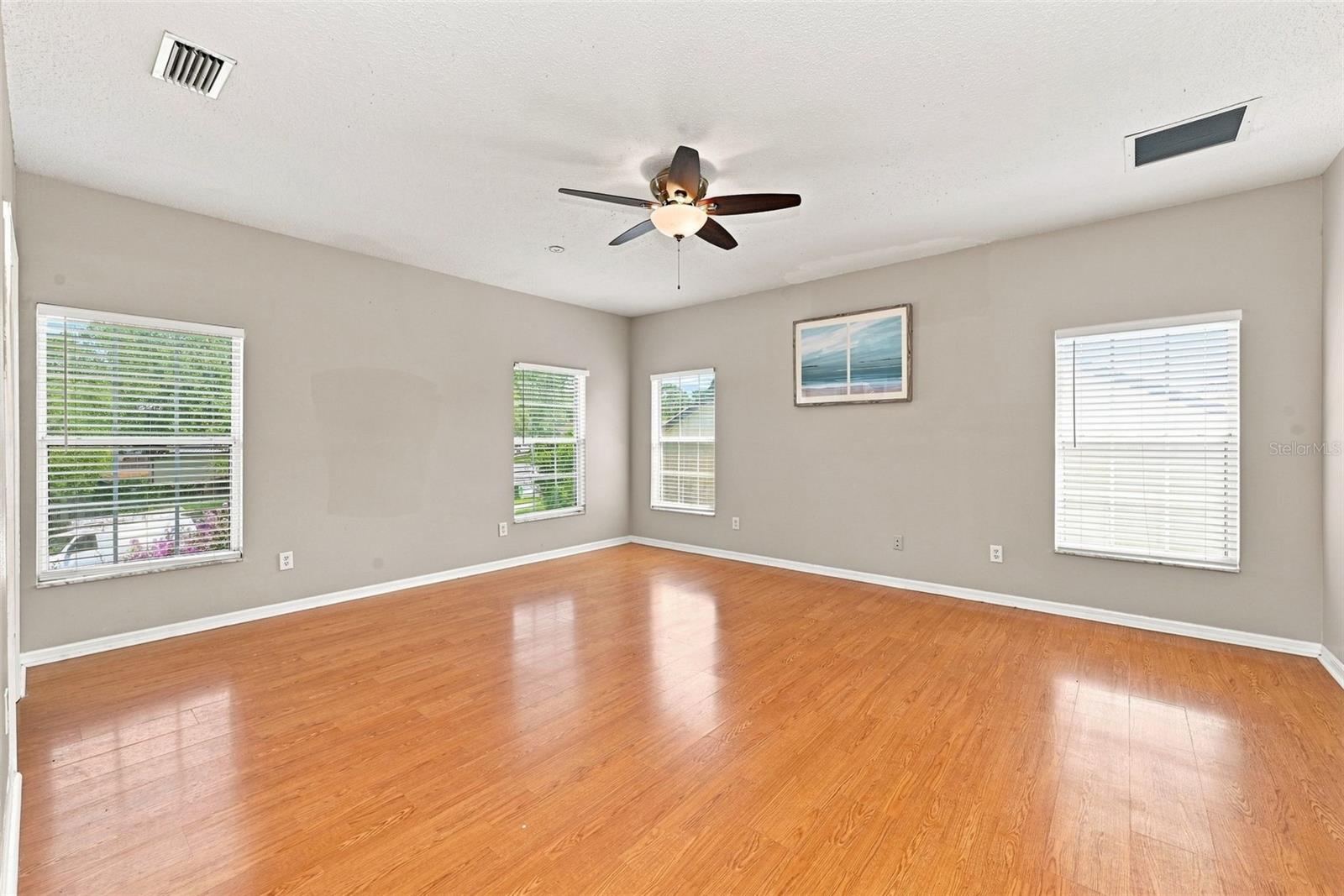 Expansive Primary Suite offers generous space, abundant natural light, and multiple windows overlooking the surrounding property.