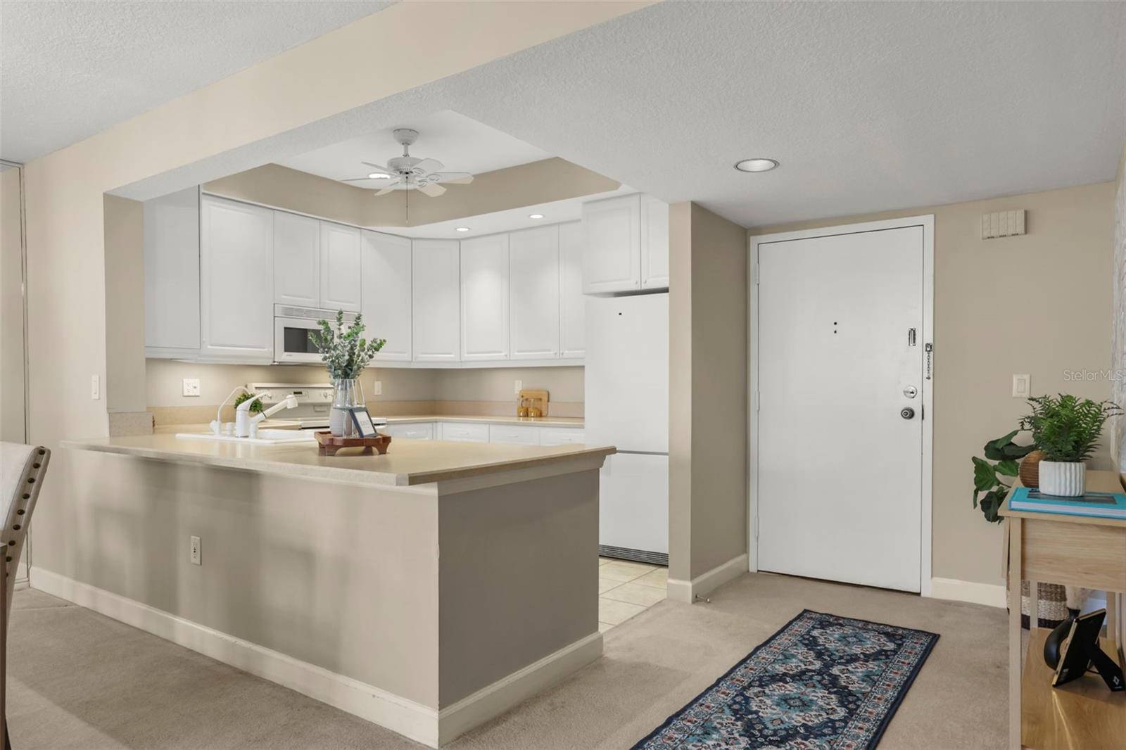 The kitchen also features a breakfast bar, 42" cabinets, recessed lighting, and an elegant flow into the roomy foyer.