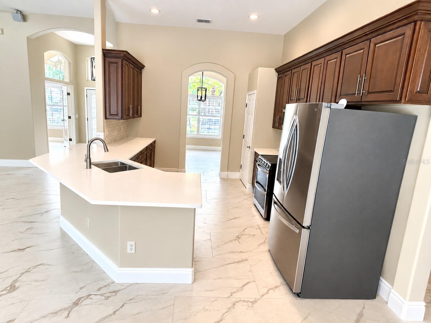 The kitchen now has a modern one level countertop/breakfast bar and the new backsplash