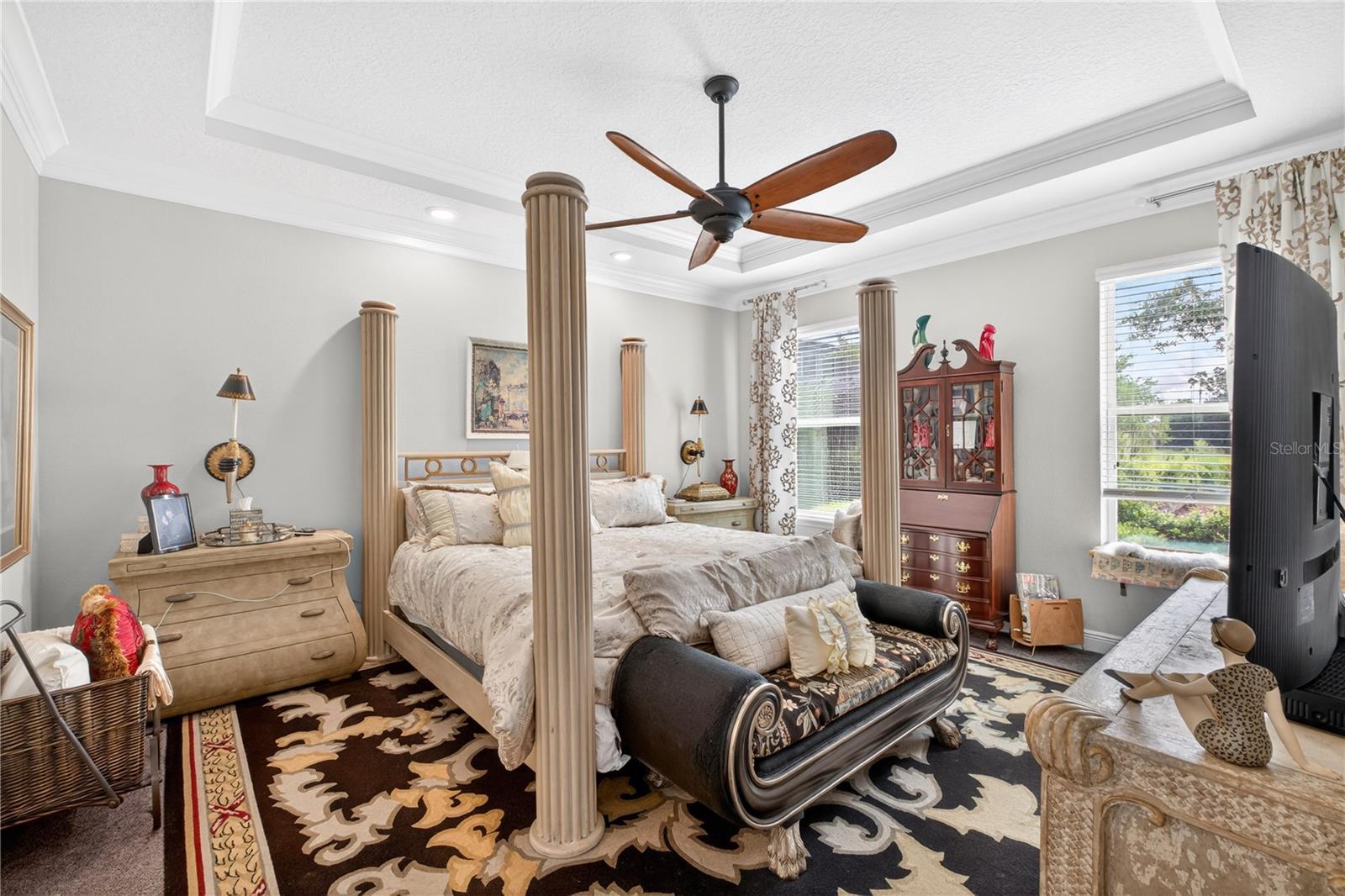 owners-suite with carpet and high ceilings featuring crown molding
