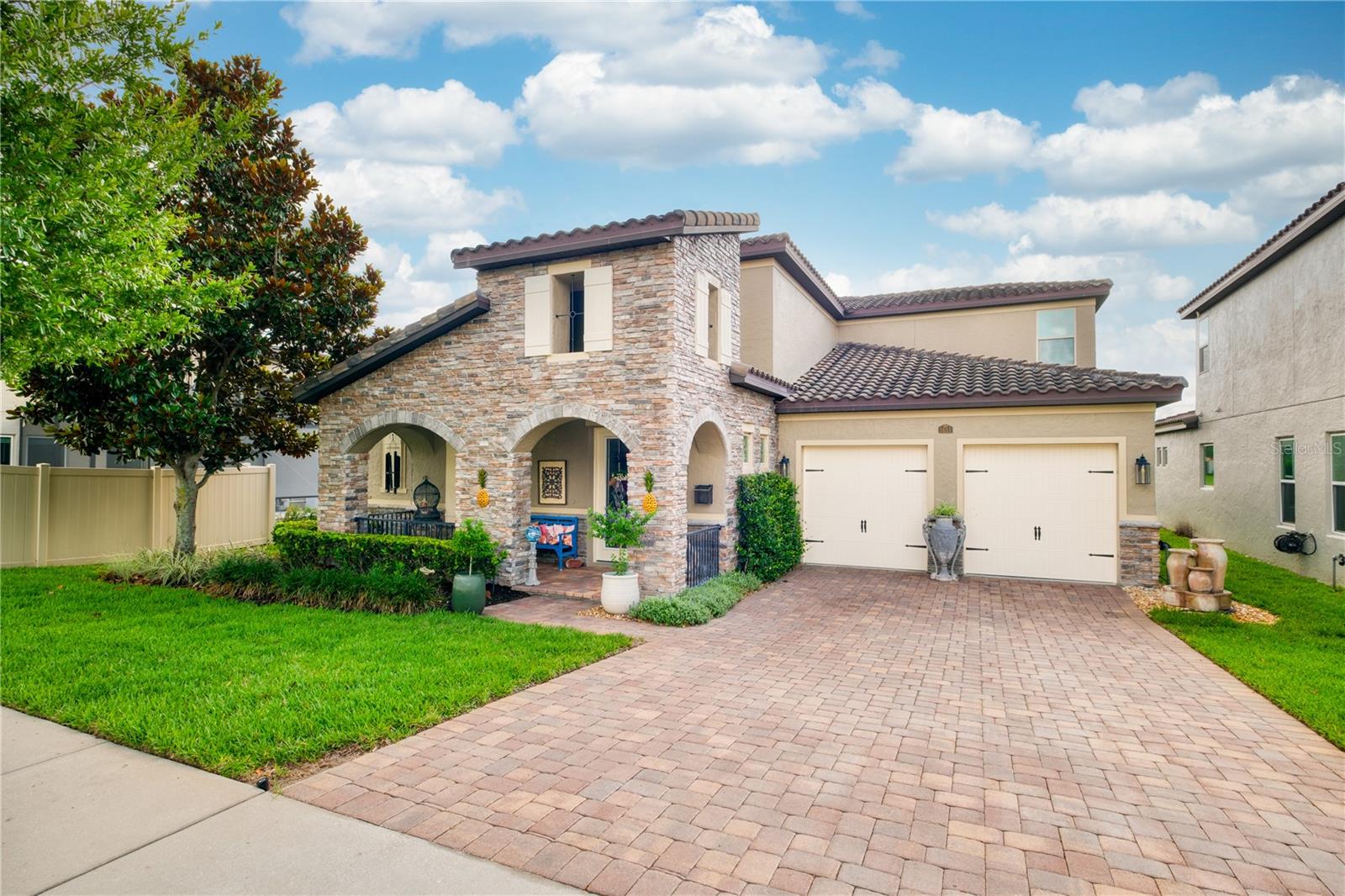 North-facing front elevation featuring a two-car garage and a welcoming front porch. North-facing front elevation featuring a two-car garage and a welcoming front porch.