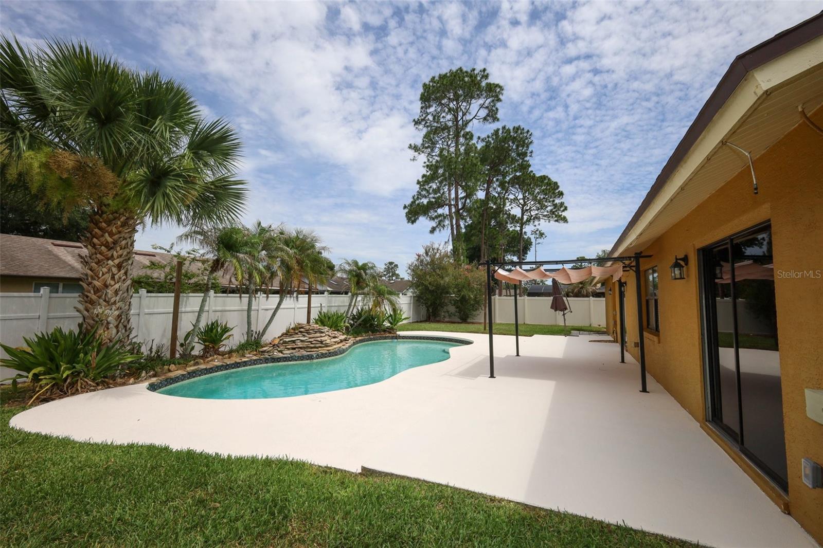 Rear yard with an open-air sparkling pool with space for the kids and pets to play.