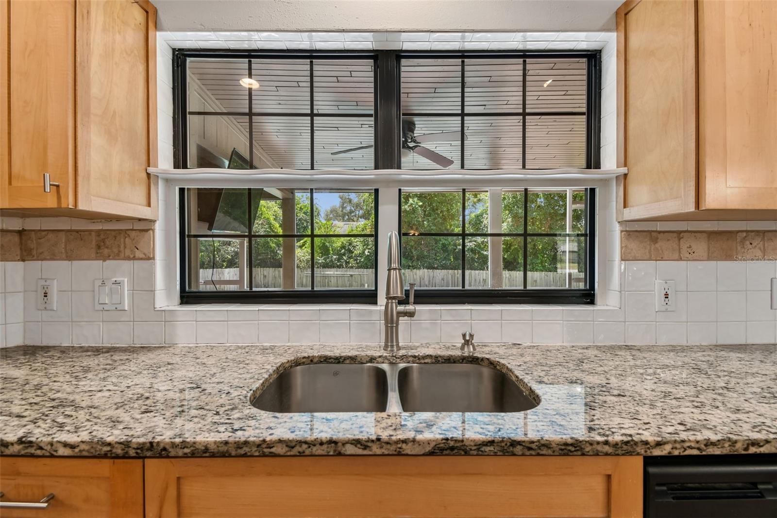 Kitchen double sink overlooks pool and porch