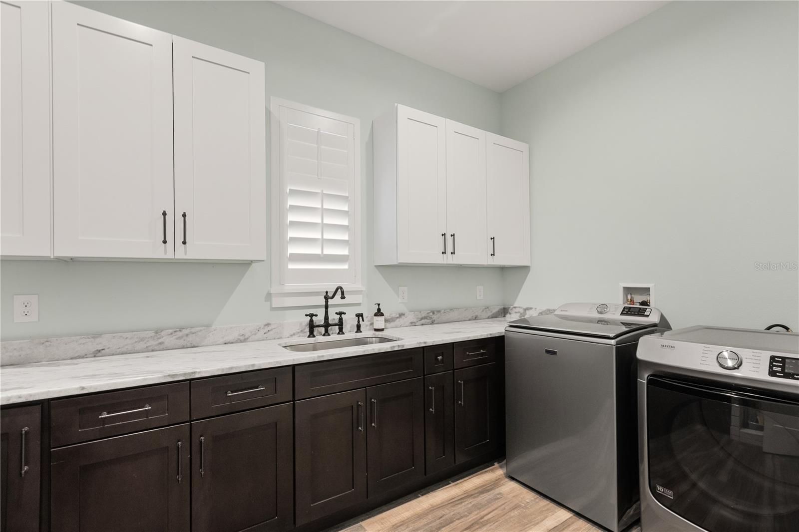 DEDICATED LAUNDRY ROOMThe dedicated laundry room features extensive cabinetry, generous counter space and a utility sink, with the mudroom and kitchen nearby.
