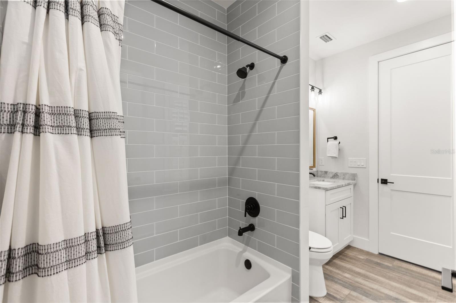 EN SUITE FULL BATH | DUAL ACCESSFull bath serving the en suite room off the foyer, with dual access from the mudroom/back entrance for added flexibility.
