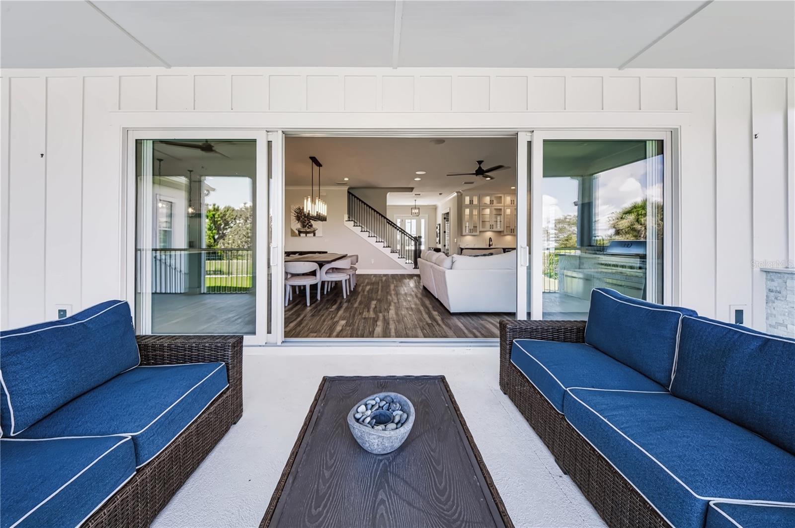 EXPANSIVE SLIDING GLASS DOORSExpansive sliders open the main living and dining areas directly to the screened porch, creating an uninterrupted connection between the interior and outdoor entertaining spaces.