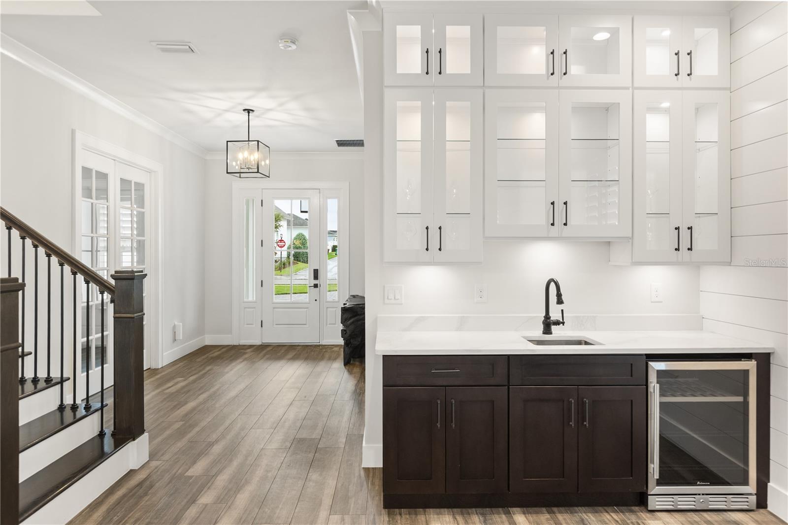 BUILT-IN WET BARA built-in wet bar with sink, beverage refrigerator and glass-front cabinetry sits just off the foyer, opening to the main living area for easy entertaining.