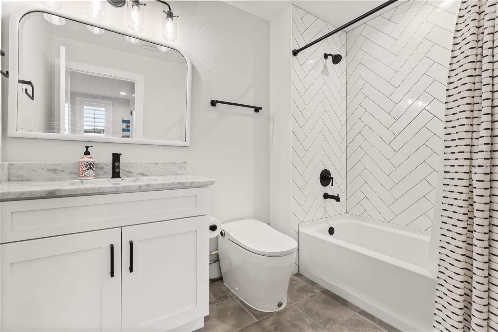GUEST HOUSE FULL BATHThe carriage house apartment includes a full bath with tub-and-shower combination and herringbone tile surround.