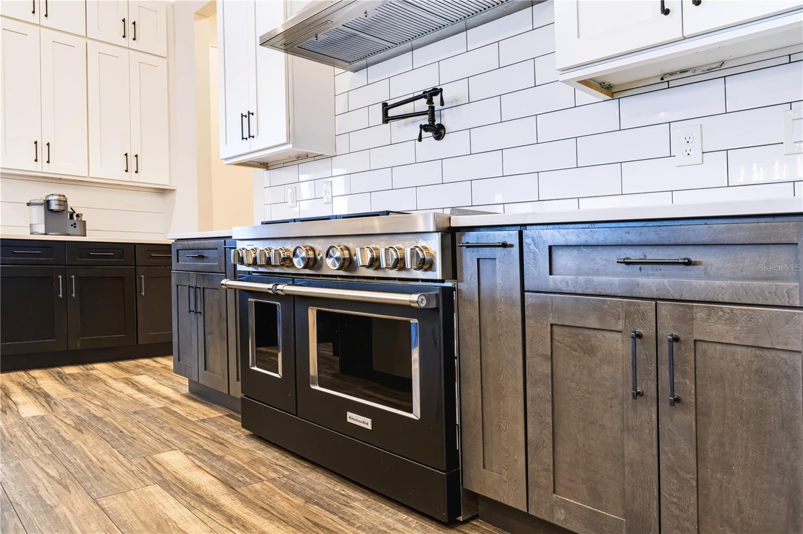 PROFESSIONAL-STYLE COOKING | KITCHEN AID OVENSA substantial range, vent hood and pot filler create a dedicated cooking zone surrounded by generous counter space and cabinetry.