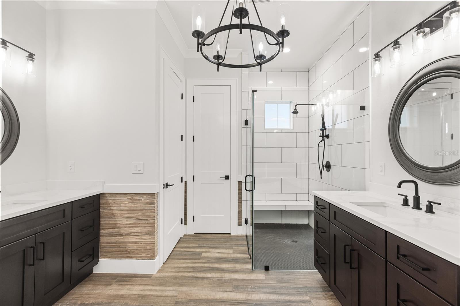 DUAL VANITIES + WALK-IN SHOWERThe primary bath includes separate vanities, a glass-enclosed walk-in shower, private water closet and a dedicated linen closet positioned beside the shower.
