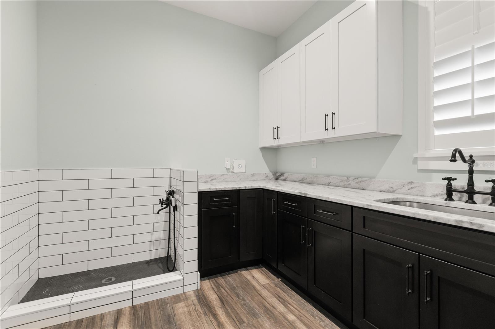 BUILT-IN DOG WASH STATIONA built-in dog wash station adds another practical feature to the laundry room, surrounded by abundant cabinetry and counter space.
