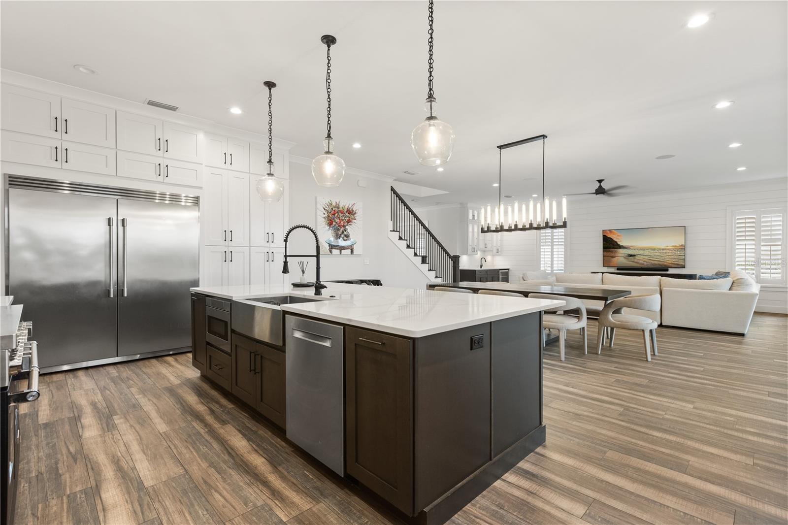 LARGE CENTER ISLANDAn oversized center island with apron-front sink and integrated appliances anchors the kitchen while remaining completely open to the dining and living areas.