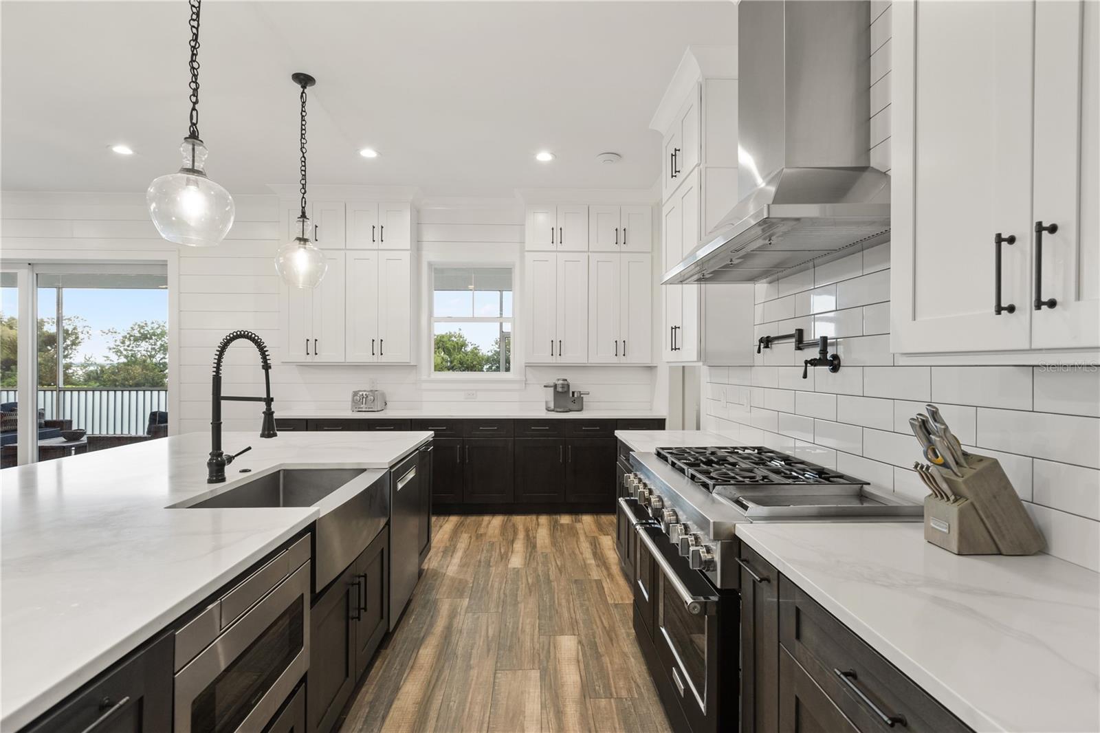 DESIGNED FOR COOKING + ENTERTAININGThe gourmet kitchen pairs an oversized center island with an apron-front sink, professional-style range, pot filler, vent hood and extensive cabinetry.
