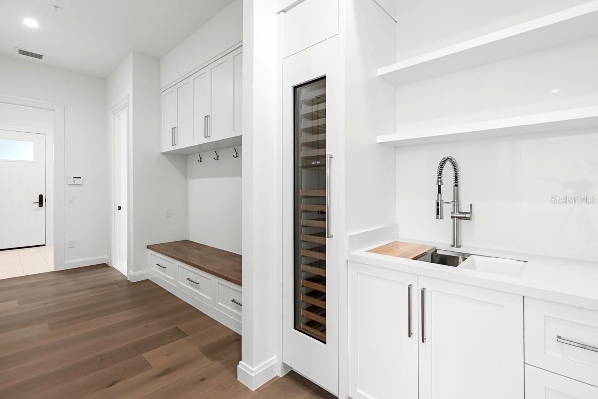 Butlers pantry directly off kitchen with walk-in pantry featuringcustom-built shelving and cabinetry