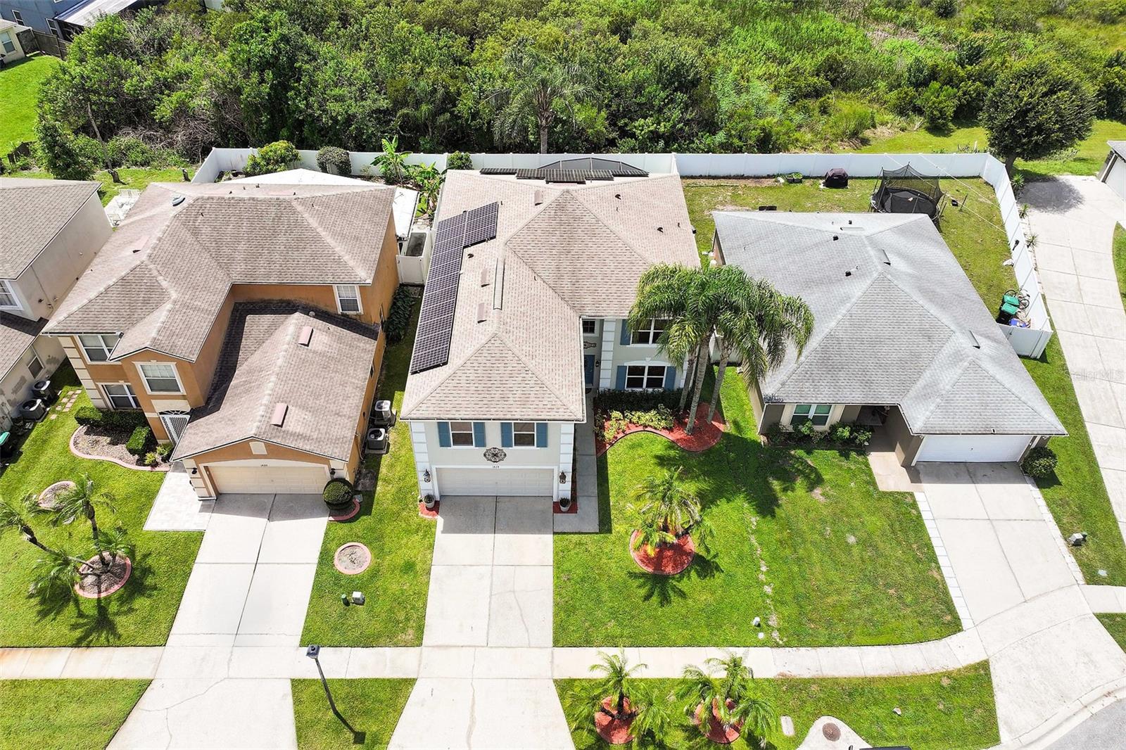 Aerial view highlighting the home's solar panels, fencing and the conservation at the back
