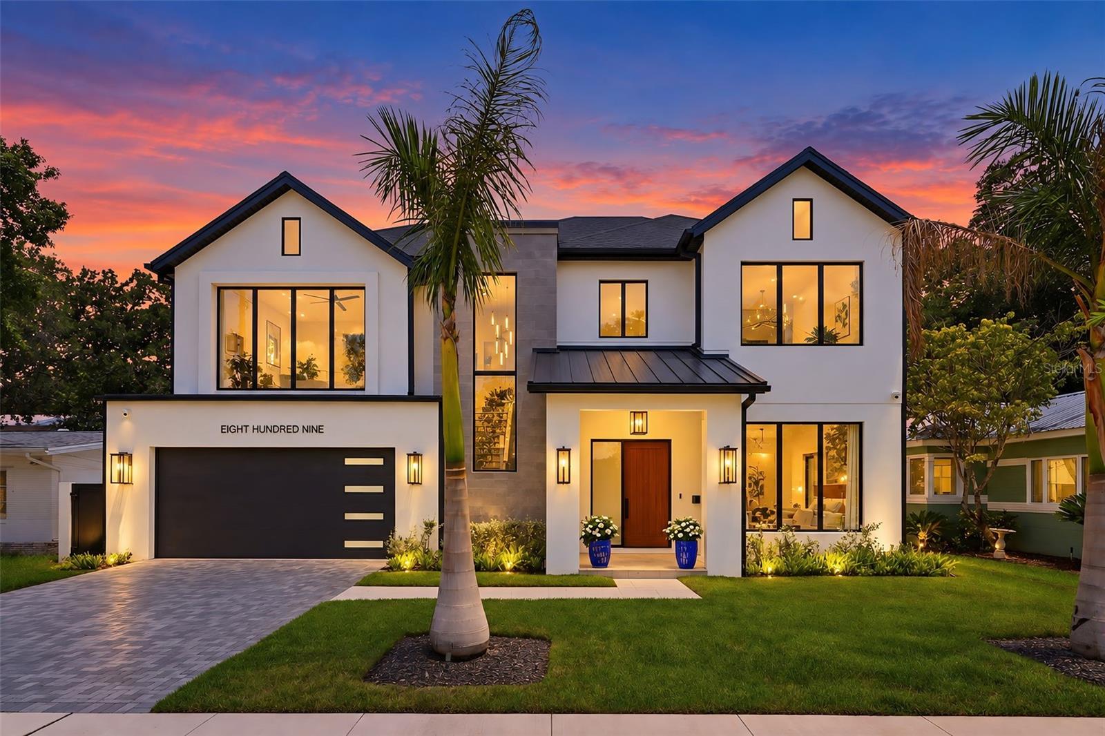 The roof combines architectural shingles with standing-seam metal accents